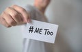 Close up hand of young man holding show a white card with word Ã¢â¬ÅMe TooÃ¢â¬Â. Social movement concept